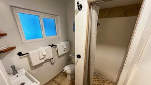 Un bagno con lavandino, WC e doccia.