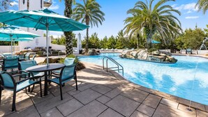 A pool area with lounge chairs, umbrellas, and palm trees. - Under New Management! Designed for Family Fun w/Golf Cart&Bikes (Santa Rosa Beach)