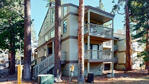 A multi-story building with balconies, surrounded by trees. - Beautiful Condo with Shared Pool & Tennis Courts, Close to Northstar (Kings Beach)