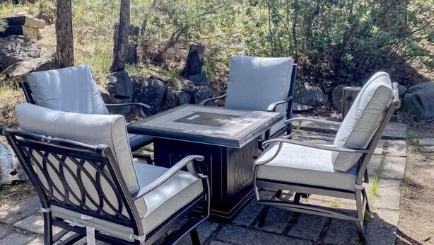 Une terrasse avec une table et quatre chaises.
