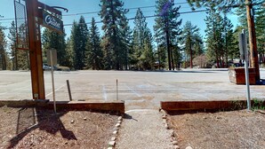 Un parking avec un panneau en bois indiquant « The Chalet ».