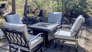 Eine Terrasse mit Tisch und vier Stühlen.