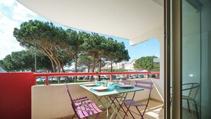 A balcony with a table, chairs, and a glass door. - Balcony facing Pontaillac beach, garage, sleeps 4. (Royan)