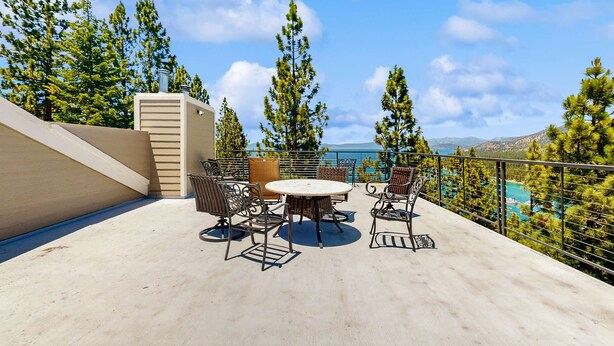 A terrace with outdoor furniture, a view of the sea, and surrounding trees. - Lake- & mountain-view lodge with hot tub, rooftop deck & pool table, sleeps 10 (Zephyr Cove)