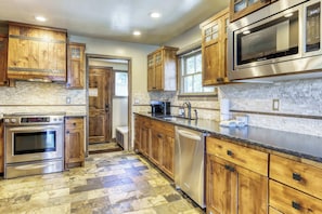A kitchen with wooden cabinets, a stainless steel oven, a microwave, and a dishwasher. - Lakeview Manor (South Lake Tahoe)