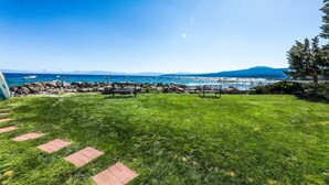 A grassy area with a view of the ocean and mountains. - Perfect Lake Retreat W/ Shared Pool, Fast WiFi, Private Patio & Easy Lake Access (Tahoe Vista)