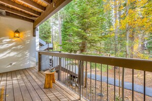 A wooden deck with a railing, a lantern, and a staircase leading to an upper level. - Olympic Valley condo with pool, hot tub, tennis, fireplace, & private balcony (Olympic Valley)