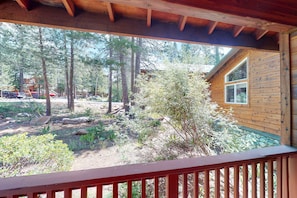 A wooden cabin with a deck overlooking a forested area. - Escape to Mountain Comfort in the Heart of Truckee, CA (Truckee)