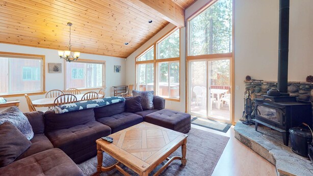 Una sala de estar acogedora con un sofá modular, una mesa de centro de madera y una chimenea de piedra.