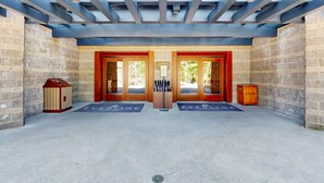 A reception area with a glass ceiling, two wooden doors, a bench, and a small wooden cabinet. - Everline Resort & Spa adjoining condos with pool, hot tub, ski-in&ski-out locale (Olympic Valley)
