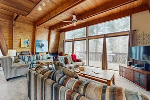 A spacious living room with a large sofa set, a television, and a ceiling fan. - Large dog-friendly home, deck, & full kitchen (Truckee)