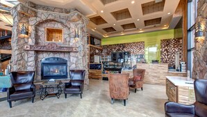 Un hall espacioso con chimenea de piedra, asientos de cuero y una zona de bar.