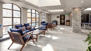 Un amplio vestíbulo con ventanas grandes, muebles de madera y un pilar de piedra.