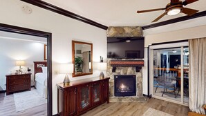 Una sala de estar con chimenea, televisión y ventilador de techo.
