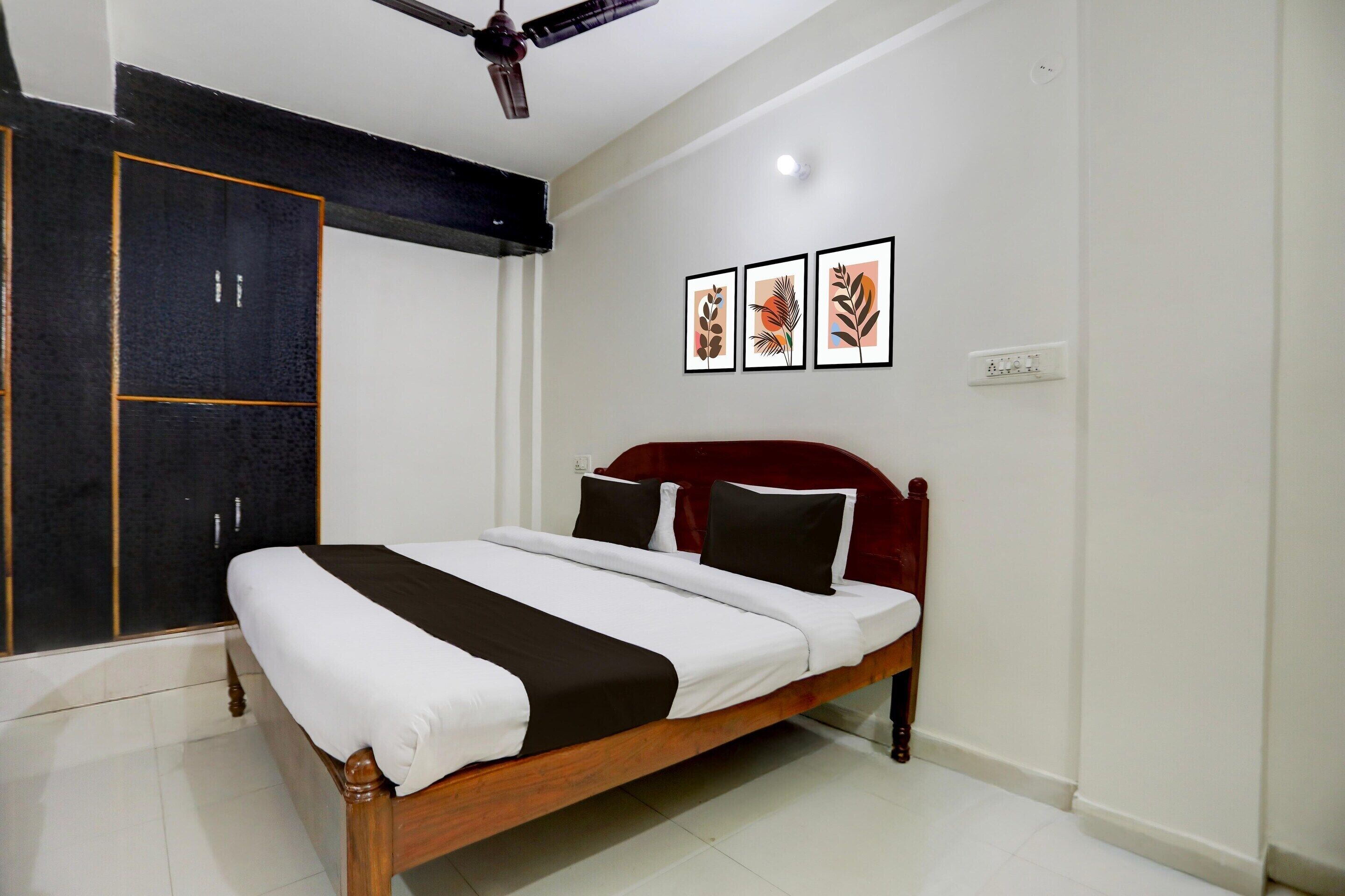 A bedroom with a bed, a wardrobe, and three framed pictures on the wall.