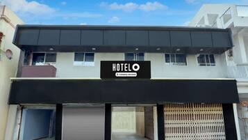 Ett hotell med en skylt som visar att det tillhandahålls tjänster för företagskunder, en överbyggd entré och en uppfart med grind.