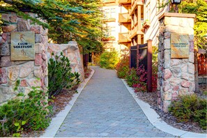 A stone pathway leading to a building with 'CLUB SOLITUDE' and 'EAGLE SPRINGS LODGE EAST' signs. - Ski-in - ski-out Condo with Shared Pool, Hot Tub & More - Awesome Views (Solitude)