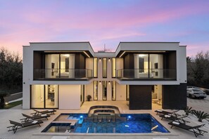 A modern two-story house with a swimming pool, outdoor seating, and a balcony. - Luxury Villa Asper by Istrabook (Liznjan)