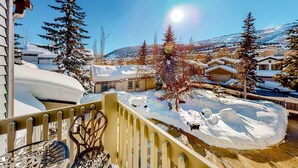 Un área residencial cubierta de nieve con casas, árboles y cielo despejado.