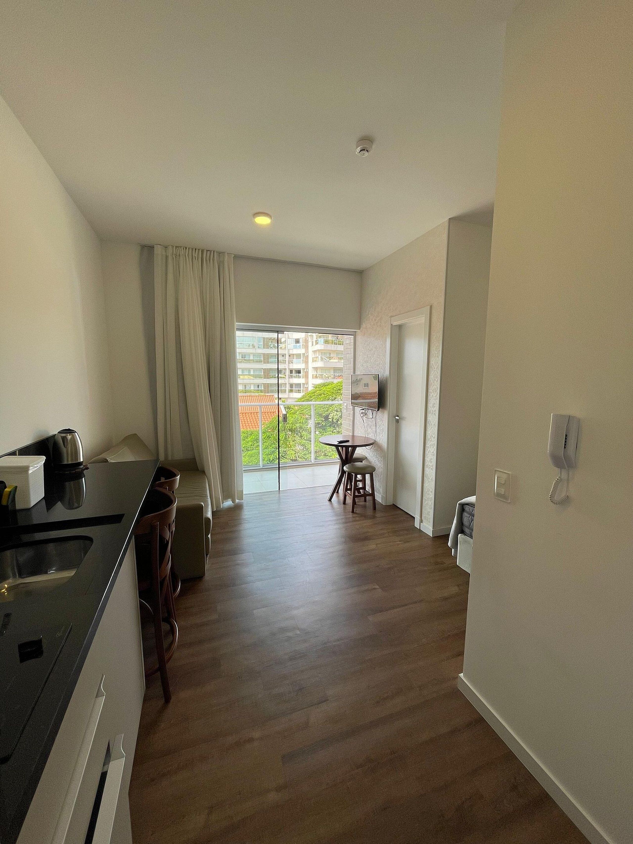 Cozinha moderna com área de jantar, varanda com vista e um telefone na parede.