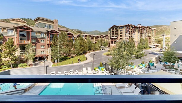 A hotel with multiple floors, outdoor swimming pool, and a view of the surrounding landscape. - Walk-to-lift studio with hot tub, sauna, pool, gym, & game room - Dog friendly (Park City)