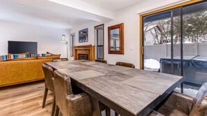 En matplats med ett stort träbord, läderstolar, en soffa och en öppen spis.