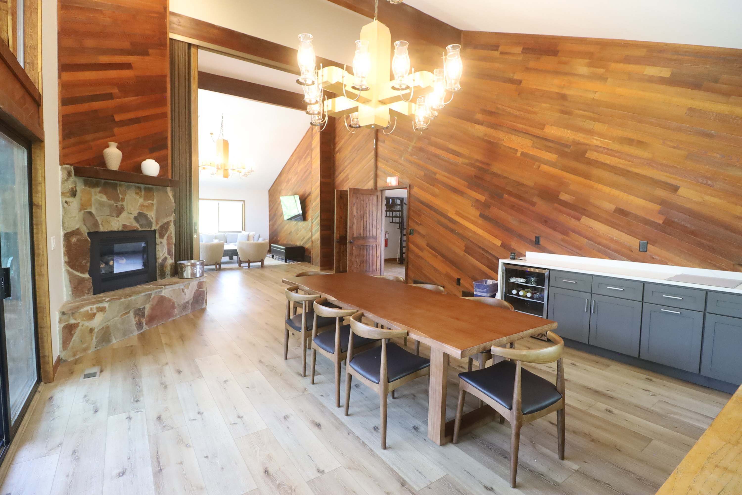 Een moderne keuken met een houten vloer, een eettafel met stoelen en een ingebouwde oven.