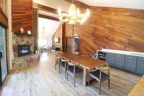 Una cocina moderna con suelo de madera, una mesa de comedor con sillas y un horno empotrado.