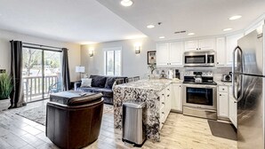 A modern kitchen with white cabinets, stainless steel appliances, and a marble island. - Updated condo w/ ski & mountain views, walk to slopes, free Wifi (Park City)