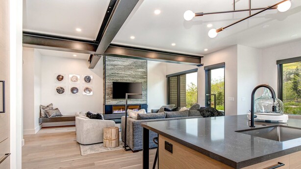Una cocina moderna con una isla central, asientos integrados y una chimenea.