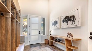A hallway with wooden flooring, a bench, a console table with a bicycle, and two wall-mounted artworks. - Townhouse in Hideout with hot tub (Hideout)