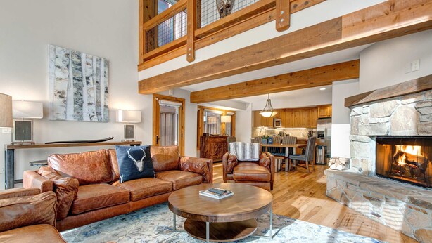 A spacious living area with a leather sofa, a coffee table, and a fireplace. - Spectacular Townhome with  a Private Hot Tub, Free WiFi, AC, & Three Fireplaces (Park City)