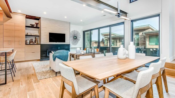 A modern kitchen with wooden cabinets, a built-in TV, and a large window. - Elegant townhome with mountain view, private hot tub, fireplace & lovely decor (Park City)