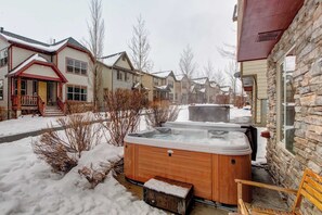 A wooden hot tub in a snowy outdoor area with houses in the background. - Contemporary Home with Private Hot Tub, Fireplace, Garage Parking, & Shared Pool (Park City)