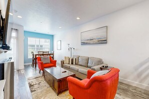 A modern living room with a sofa, two armchairs, a coffee table, and a dining area with a table and chairs. - Mountain Getaway - Private Rooftop Spa - Walk to Dining, Shops & Rec Center (Park City)