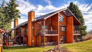 A modern two-story house with a large balcony, a chimney, and a stone foundation. - Two Lofts, Mountain Views, Gas Fireplace, Shared Seasonal Hot Tub & Pools (Park City)