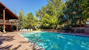A swimming pool with lounge chairs and a wooden deck. - Two Lofts, Mountain Views, Gas Fireplace, Shared Seasonal Hot Tub & Pools (Park City)