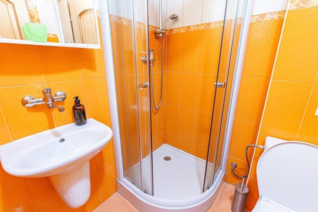 Et badeværelse med bruser, vask og toilet.