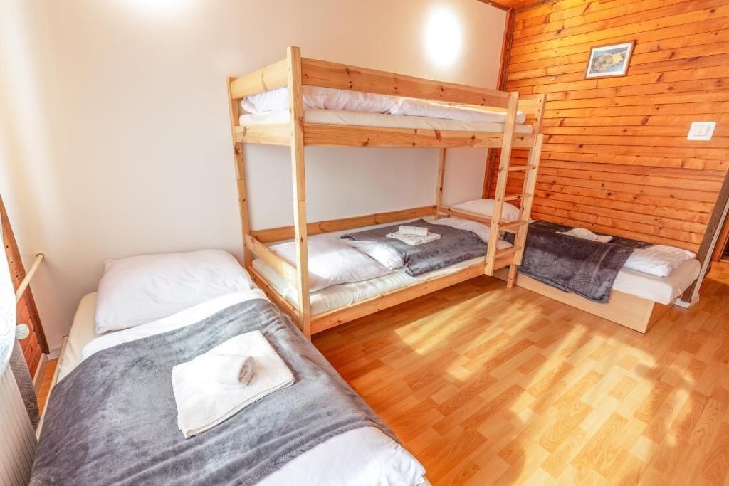 Une pièce avec deux lits superposés, un plancher en bois et un mur en bois.