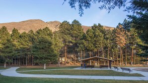 Un parc avec un kiosque, des bancs et un sentier.