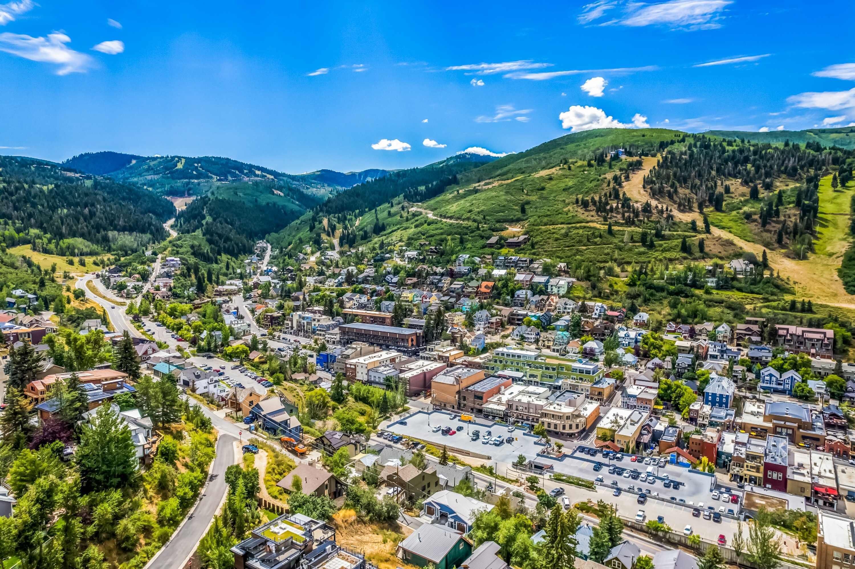 A town with a central road, buildings, and surrounding hills.