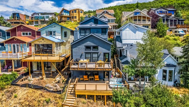 Una zona residencial costera con varias casas, incluyendo una casa azul destacada con un porche y una casa blanca con balcón.