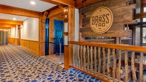 Un vestíbulo de hotel con interior de madera, una puerta azul y un letrero que dice 'BRASS TAG'.
