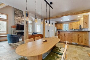 Una cocina amplia con armarios de madera, una isla grande y lámparas colgantes.
