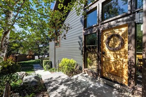 A modern house with a wooden door, a stone wall, and a garden with a pathway. - Spacious ski getaway with private hot tub & game room -Close to little and big Cottonwood Canyons (Sandy)