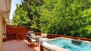 A hot tub on a wooden deck with outdoor furniture and a view of trees. - Terrific, central location for ski resort access with  private hot tub & fireplace (Cottonwood Heights)