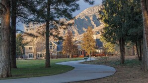 A park with a curved pathway, trees, and a mountain in the background. - Terrific, central location for ski resort access with  private hot tub & fireplace (Cottonwood Heights)