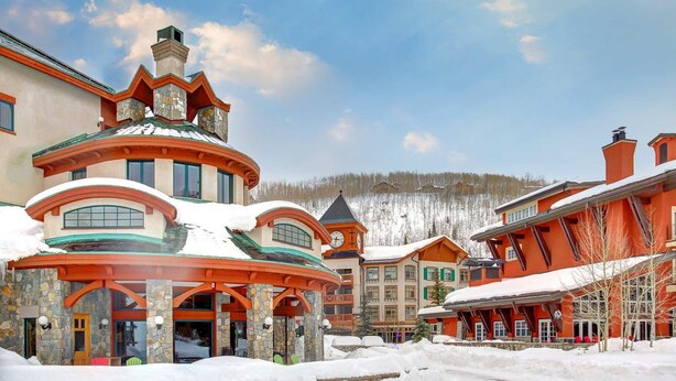 A snow-covered resort with multiple buildings, including a prominent circular structure with a red roof. - Terrific, central location for ski resort access with  private hot tub & fireplace (Cottonwood Heights)