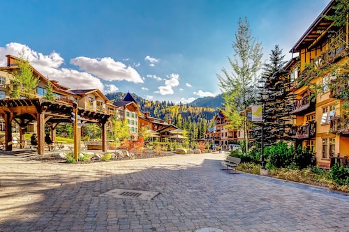 ski-in - ski-out condo with a deck, ski views & a shared pool and hot tub