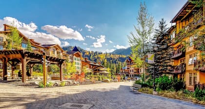 ski-in - ski-out condo with a deck, ski views & a shared pool and hot tub